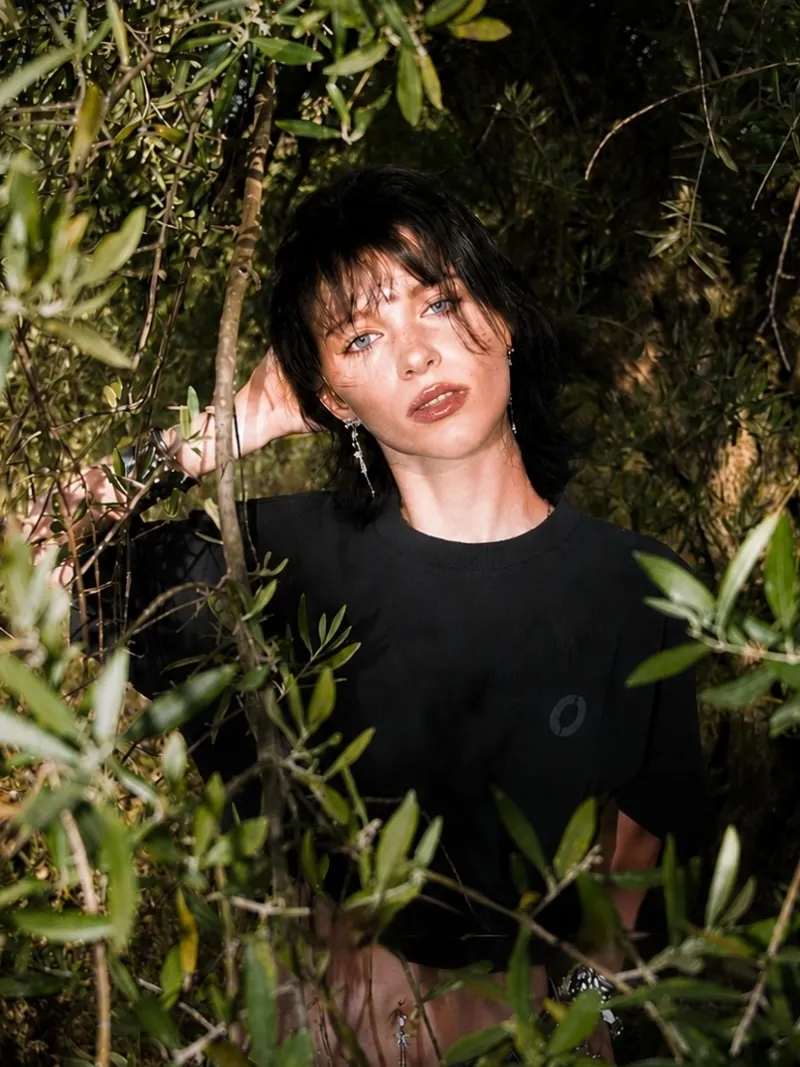 A black Scope House tee among olive branches