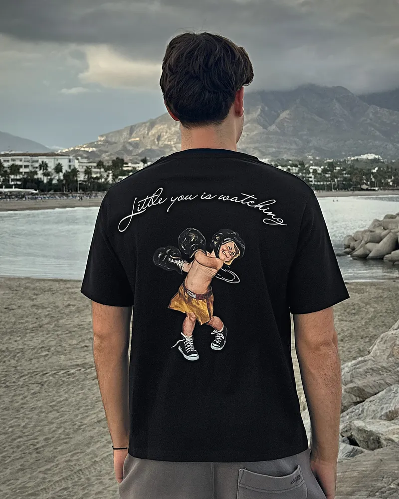 Little you in black, worn, seen from the back on the beach at Puerto Banús