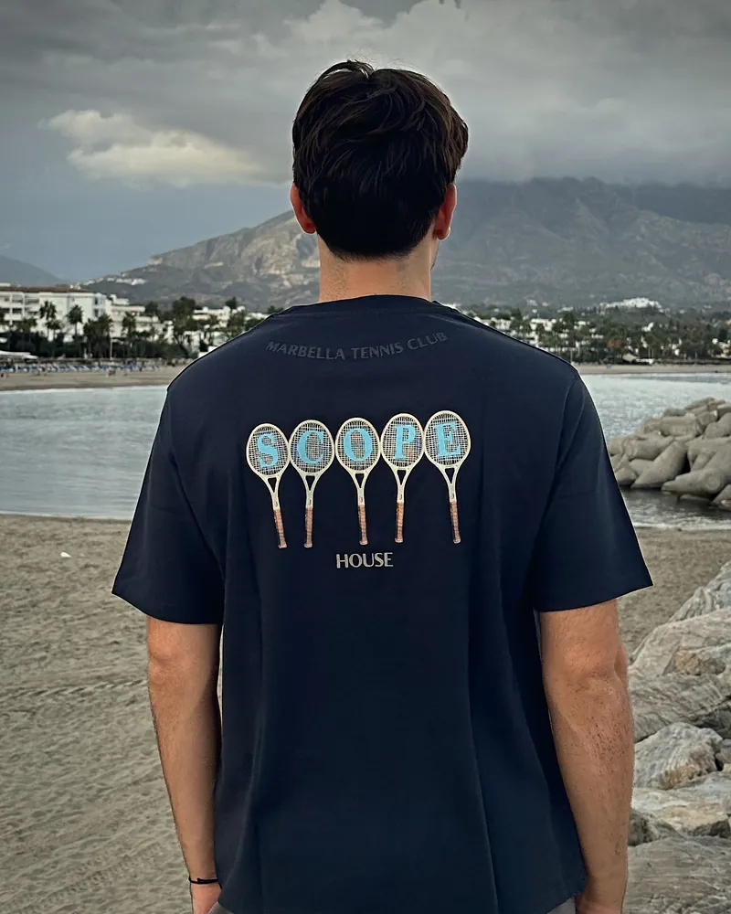 Scope rackets in navy, worn, seen from the back on the beach at Puerto Banús